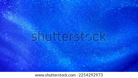 Blue liquid background with small pearlescent luminous particles. Abstract textured Blue flowing waves background with shiny streaks. Magic blue waves with tints of silver dust particles.