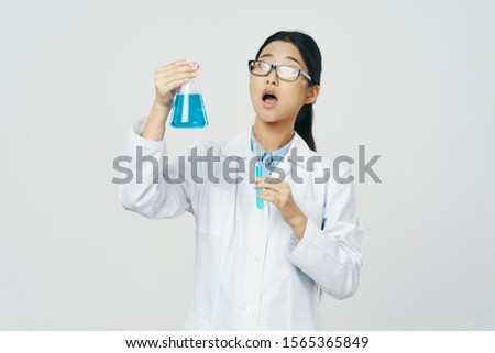 Blue liquid in the club beautiful woman in glasses and a medical gown