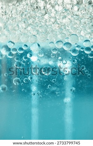 Blue liquid creating an abstract texture with transparent bubbles forming on the surface