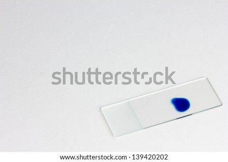 Blue liquid on a microscope slide/Microscope slide/Isolated