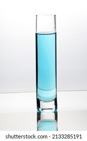 Blue Liquid Pouring Into Tall Glass On Bright Field High Key Background