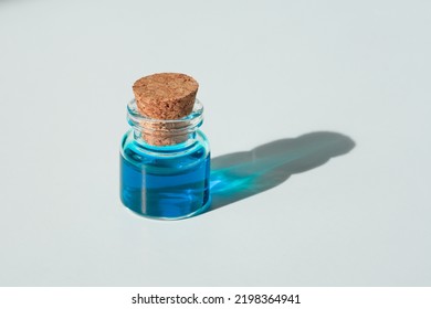 Blue Liquid In A Small Jar On A White Background. Blue Dye In A Beaker. A Sample Of Azure Paint.