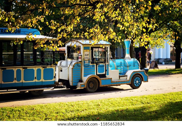        \
   Blue locomotive with wagons on wheels for excursions and trips\
through the autumn park                   \
