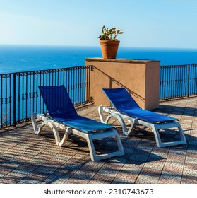 blue lounge chair in a hotel with water and swimming pool on background , vacation resort landscape of a beautiful place for holiday relax, tourism season concept - Shutterstock ID 2310743673