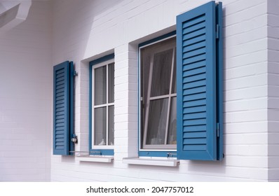 blue louvered window shutters on a white house