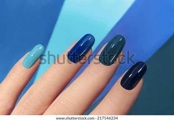 	  Blue manicure in light and dark colors of\
lacquer on a striped\
background.