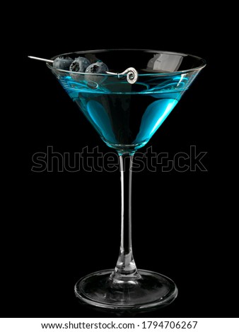 Blue martini cocktail with blueberries