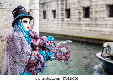 Blue masked carnaval costume with hat catching a ride next to famous Bridge of Sighs, Venice,Italy. - Shutterstock ID 376220056