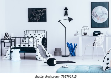 Blue Mattress And Black Lamp Next To Bed In Teenager's Bedroom Interior With Poster Of The Moon On White Wall Above Desk