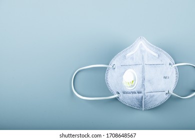 A blue medical face mask on blue background - Shutterstock ID 1708648567