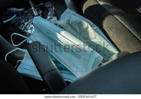 Blue medical mask in the car. The mask is placed on\
the car seat.
