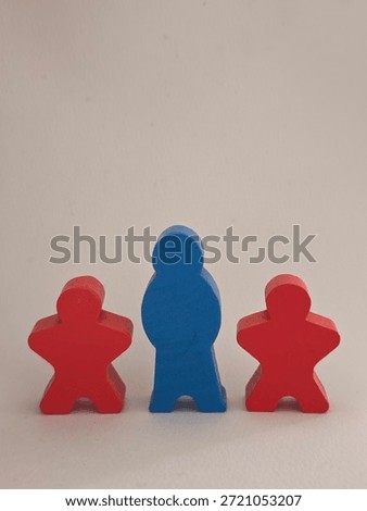 Blue meeple centered between two red figures, suggesting hierarchy or role distinction in board game context.