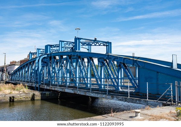 Blue metal bridge over\
water