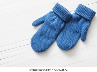 Blue Mittens On White Wooden Background