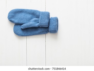 Blue Mittens On White Wooden Background