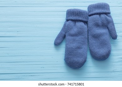 Blue Mittens On Blue Wooden Background