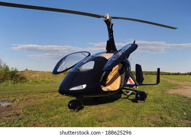Blue modern autogyro parked on the private airfield