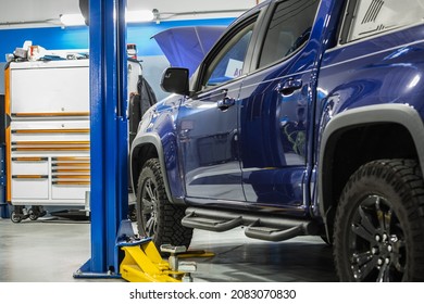 Blue Modern Pickup Truck Scheduled Maintenance Inside Dealership Auto Service Area. Automotive Industry Theme.