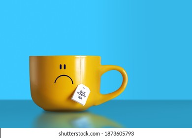 Blue Monday tea text with sad face on big yellow cup on blue background. The most depressing day of the year. Blue Monday breakfast concept. Copy space. 
