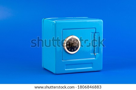 Blue moneybox (piggy bank) made as safe. on blue background  with copy space