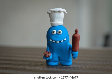 Blue monster chef holding a rolling pin and cookies.