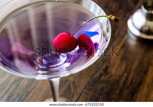 Blue Moon\
Cocktail with cherry on wooden\
surface.\
