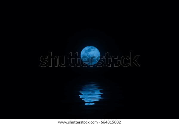 Blue moon\
night with water reflection on the\
sea.