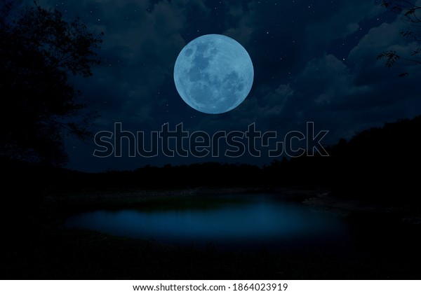 Blue moon over the lake at\
night.