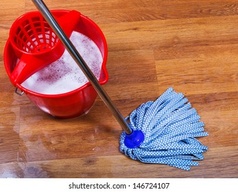 Blue Mop And Red Bucket On Wet Floor