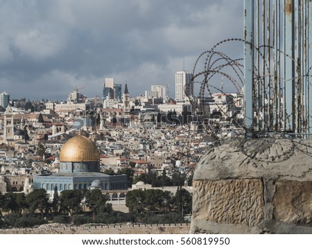 The blue mosque in jerusalem alongside a wall and barbed wire symbol of divisions and hate present between jews and muslims in holy land
