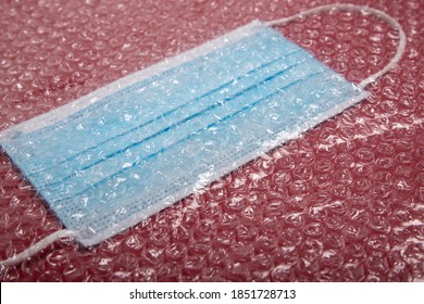 Blue Mouthguard Under A Plastic Bubble Wrap On A Red Background, Perspective View