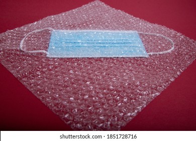 Blue Mouthguard Under A Plastic Bubble Wrap On A Red Background, Perspective View