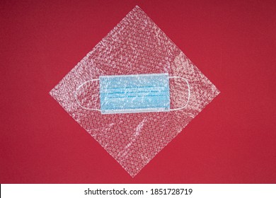 Blue Mouthguard Under A Plastic Bubble Wrap On A Red Background, Shot From Above