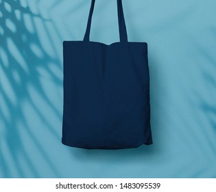 Blue Navy Canvas Tote Bag or Goodie Bag Isolated with Palm Leaf Shadow on Wall Background - Shutterstock ID 1483095539