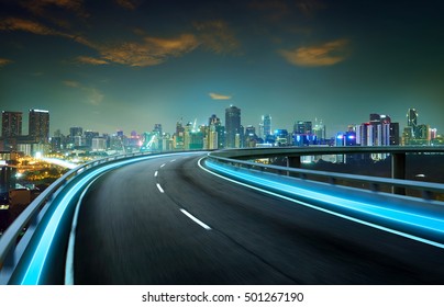 Blue neon light highway overpass motion blur with city  skyline background , night scene . - Powered by Shutterstock