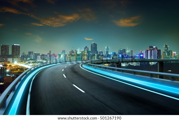 Blue neon light highway
overpass motion blur with city  skyline background , night scene
.