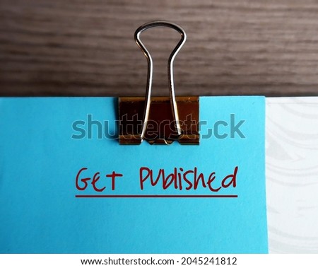 Blue note and document clip, with text written GET PUBLISHED,concept of book writer author must get their manuscript to be read by editors and published by publisher or self-publishing