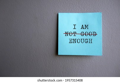 Blue note on gray wall with text I AM NOT GOOD ENOUGH with red crossing on NOT GOOD , concept of self worth , stop striving for approval, more valid , more loved or validation , you are good enough - Shutterstock ID 1957315408