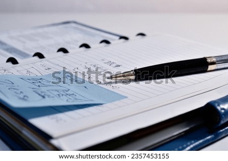  A blue notepad with sticky notes and a premium ballpoint pen