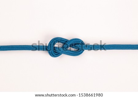 Blue nylon rope in figure 8 knot on white