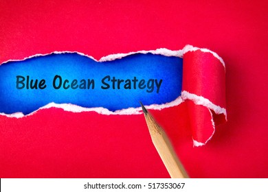 Blue ocean strategy word on Torn red Paper and space with  a blue paper background