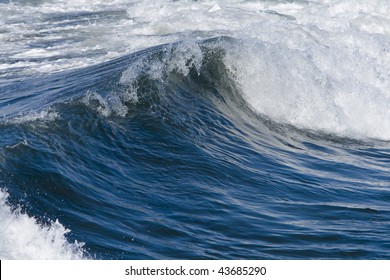Blue ocean and surf with waves on bright, sunny day.