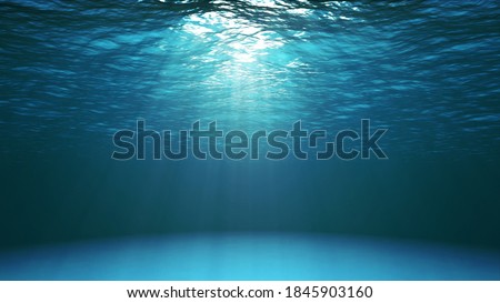Blue ocean surface seen from underwater. Abstract waves underwater and rays of sunlight shining through water