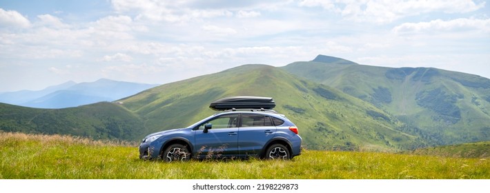 Blue off road car on mountain trail. Traveling by auto, adventure in wildlife, expedition or extreme travel on SUV automobile