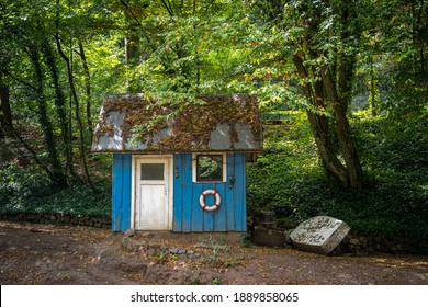 Blue old cabin with boat in the woods