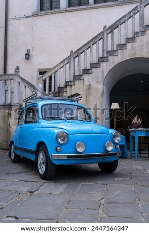 Blue Oldtimer infront of staircase of an old town