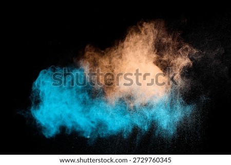 Blue and orange powder exploding on black background