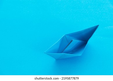 Blue Origami Boat On Blue Background.