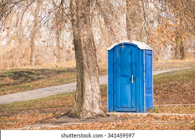 Blue outdoor chemical toilet in the park in winter