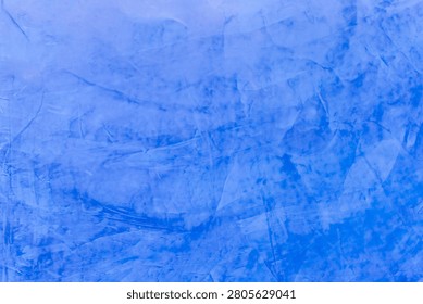 Blue painted plaster wall texture with layered brush patterns subtle tonal variation and artistic finish ideal for backgrounds decorative design and creative projects